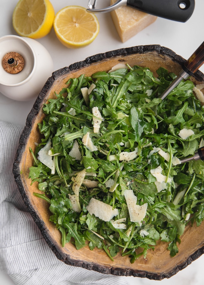 overhead of arugula and shaved fennel salad in a wood bowl