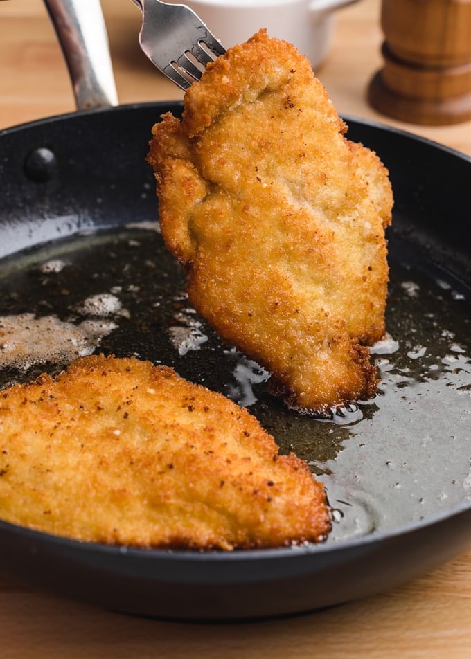 breaded chicken cutlets fried in olive oil in a skillet