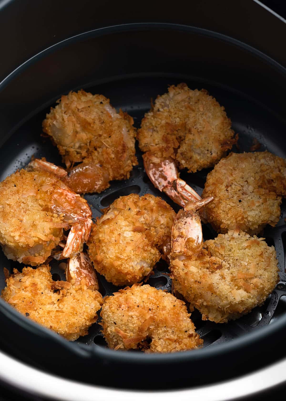 cooked coconut shrimp in an air fryer basket