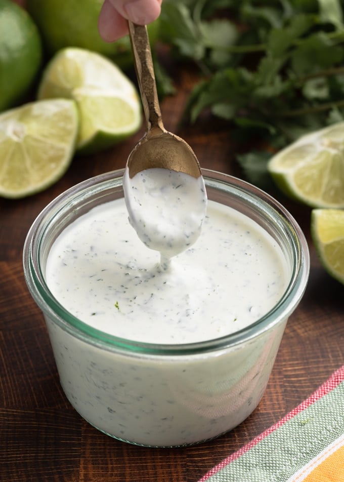 a spoonful of chipotle lime crema in a glass jar