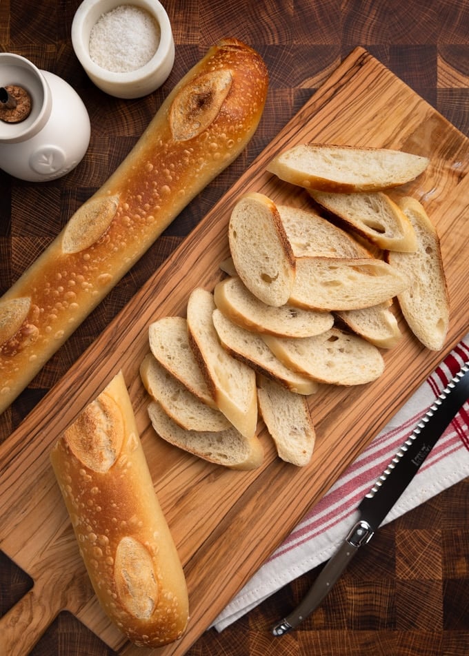 slices of baguette on a wood bread board