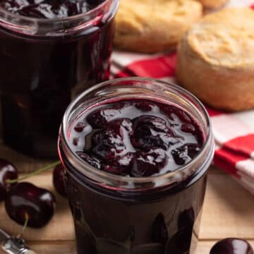 no-pectin cherry preserves in glass jam jars on a wood board