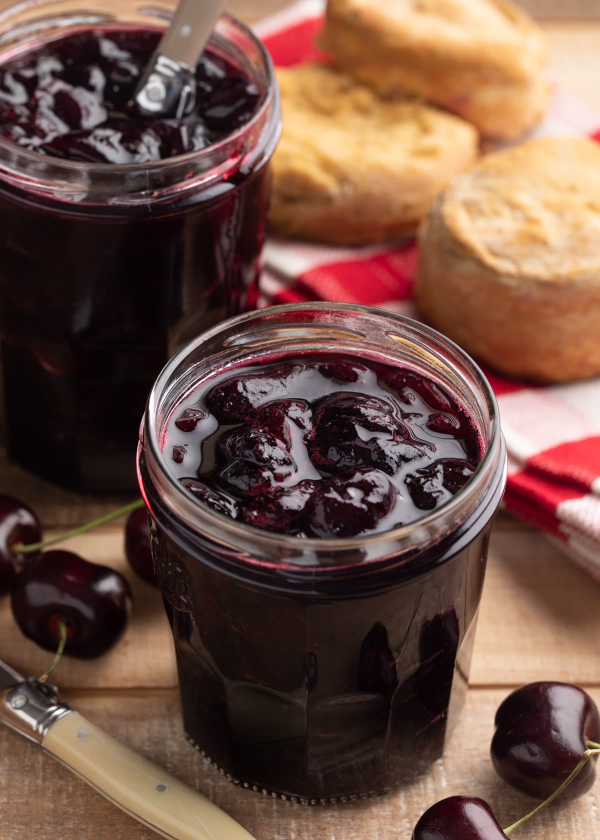 no-pectin cherry preserves in glass jam jars on a wood board