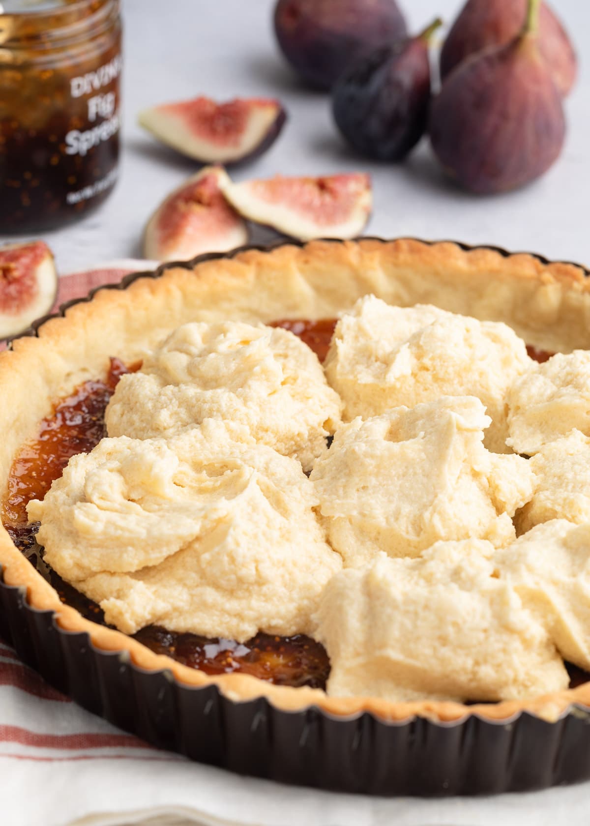 dollops of almond cream in a par-baked tart shell spread with fig jam