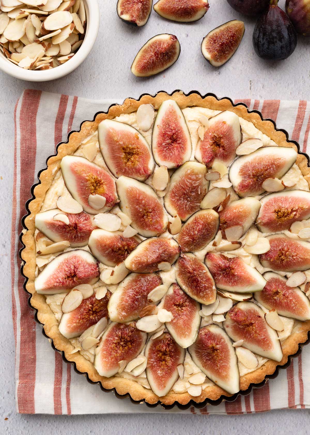 overhead of an unbaked fig tart on a red and white striped napkin