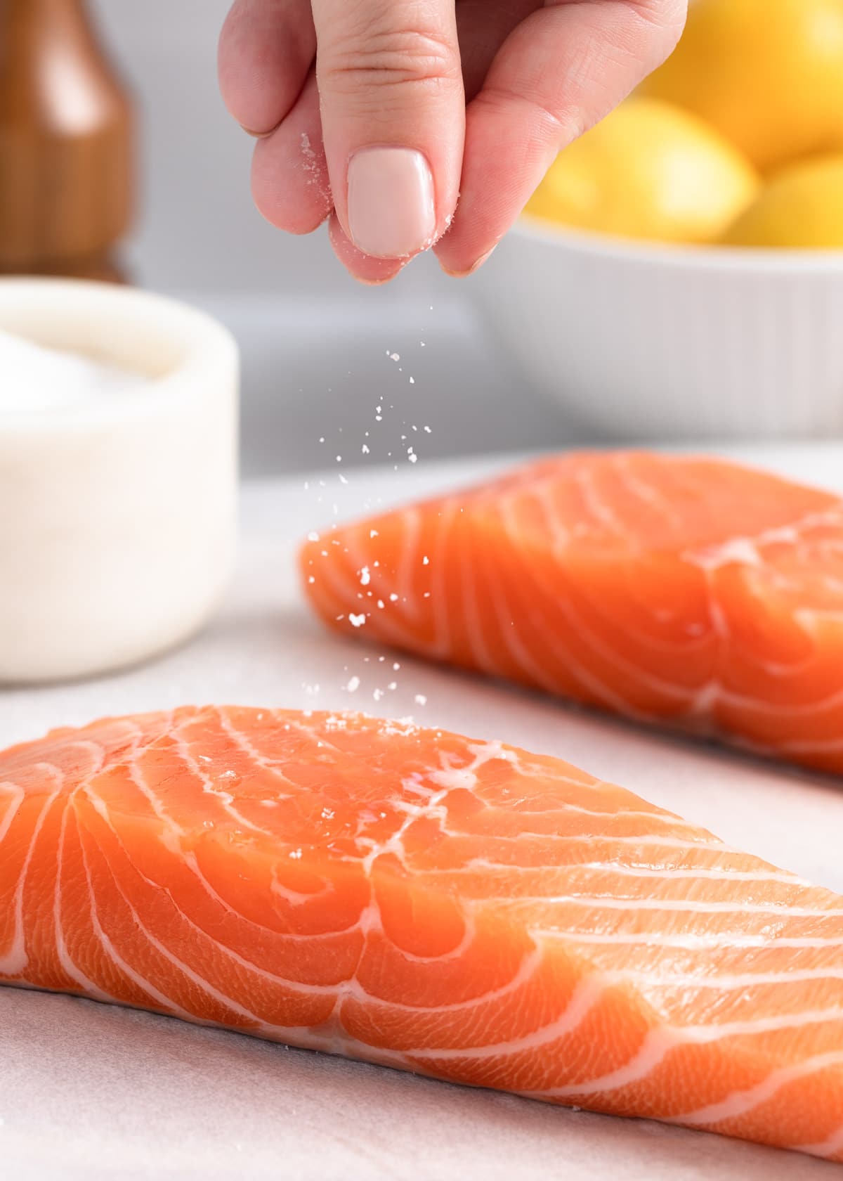 sprinkling salt onto a salmon fillet