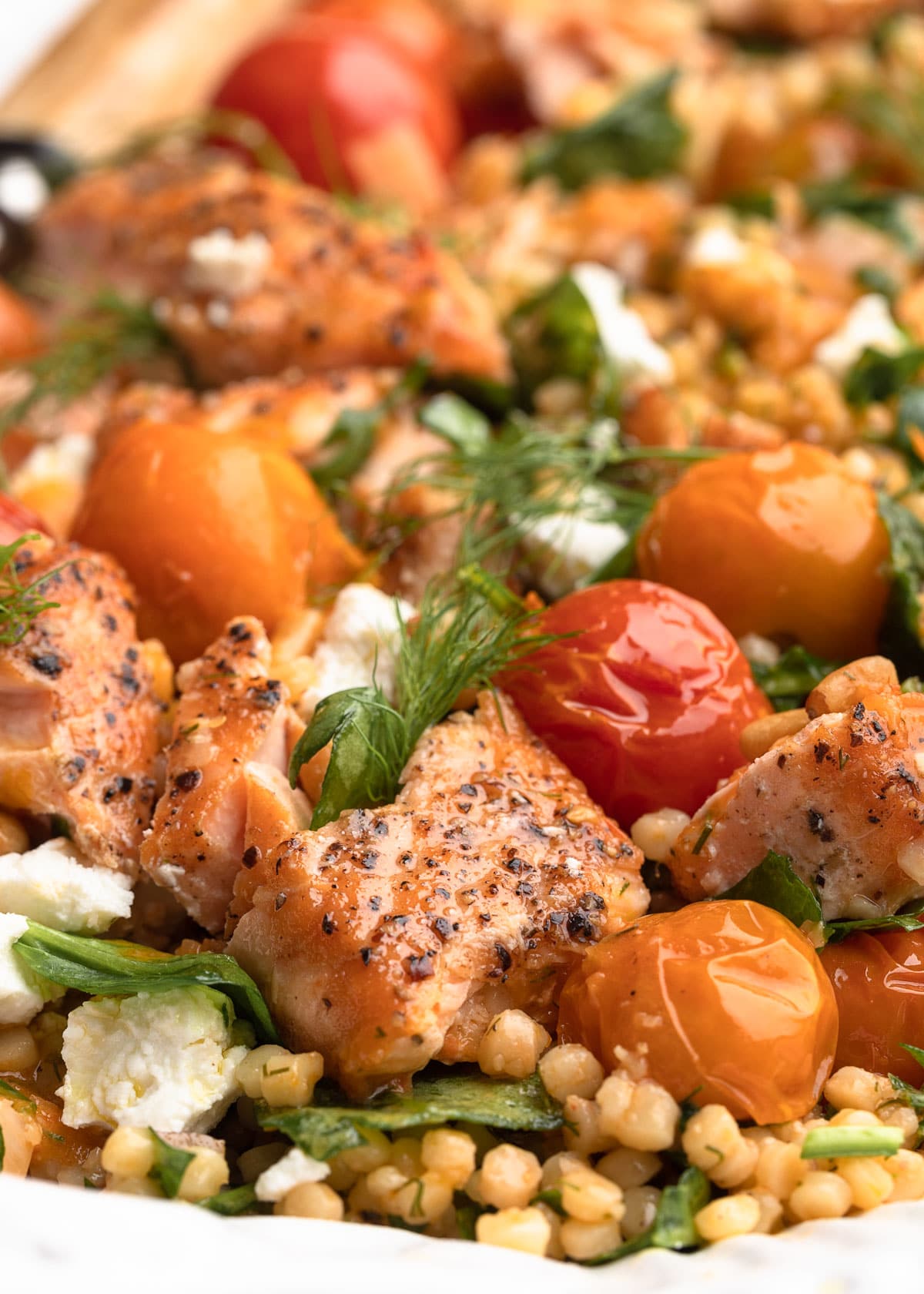 closeup side view of salmon couscous salad on a serving platter