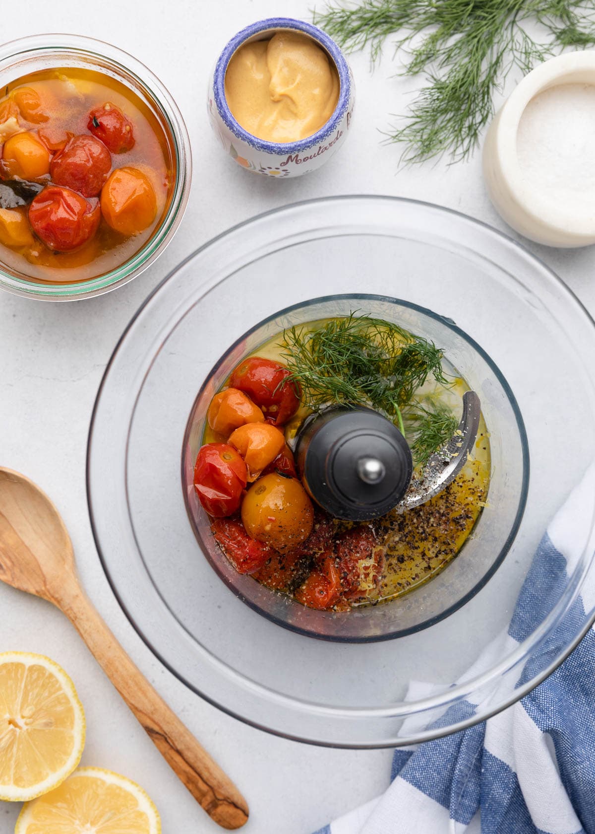 roasted tomatoes, fresh dill, and lemon juice in the bowl of a mini food processor