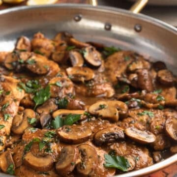 side view of chicken marsala in a copper frying pan