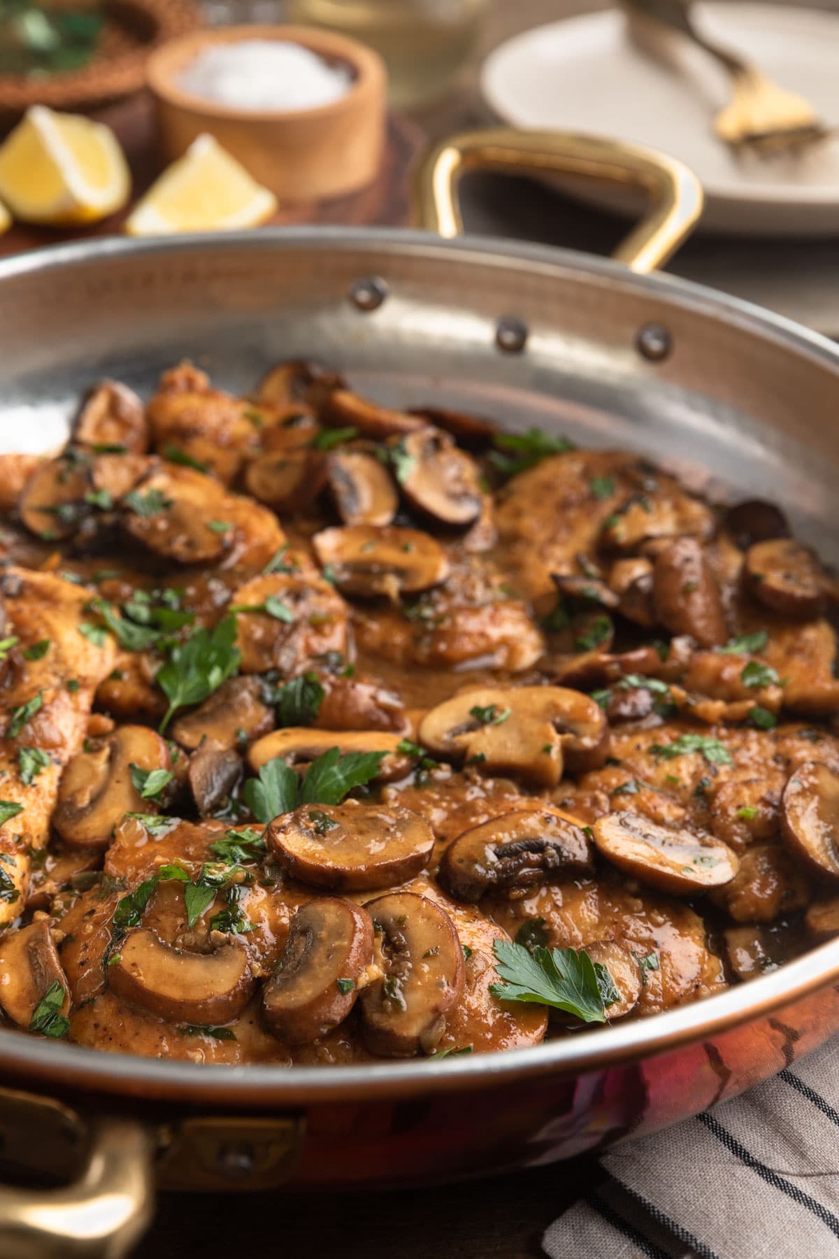 side view of chicken marsala in a copper frying pan