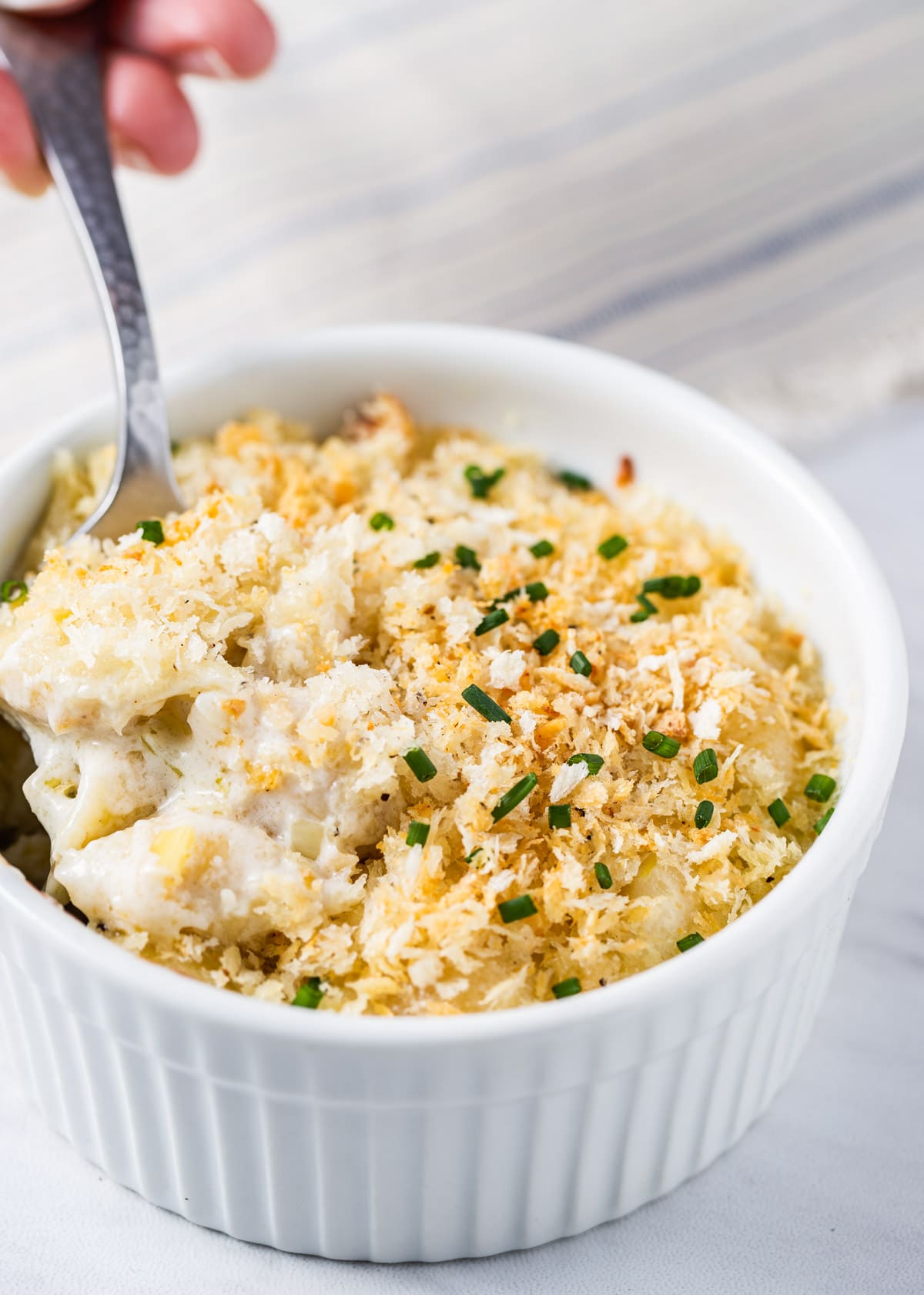 gourmet mac and cheese made with gorgonzola and fontina in a white ramekin with a spoon