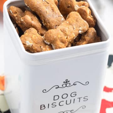 homemade pumpkin dog treats in a white dog biscuit canister