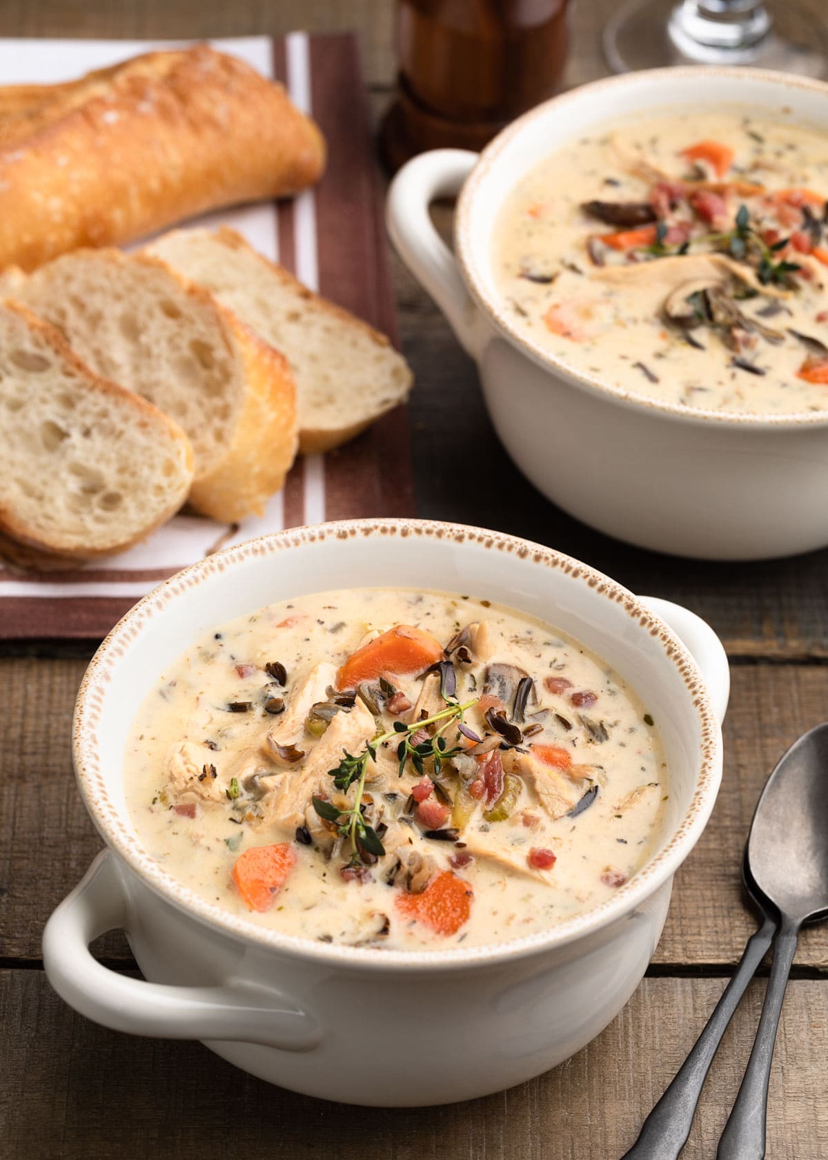 creamy leftover turkey and wild rice soup in white ceramic bows on a wood board