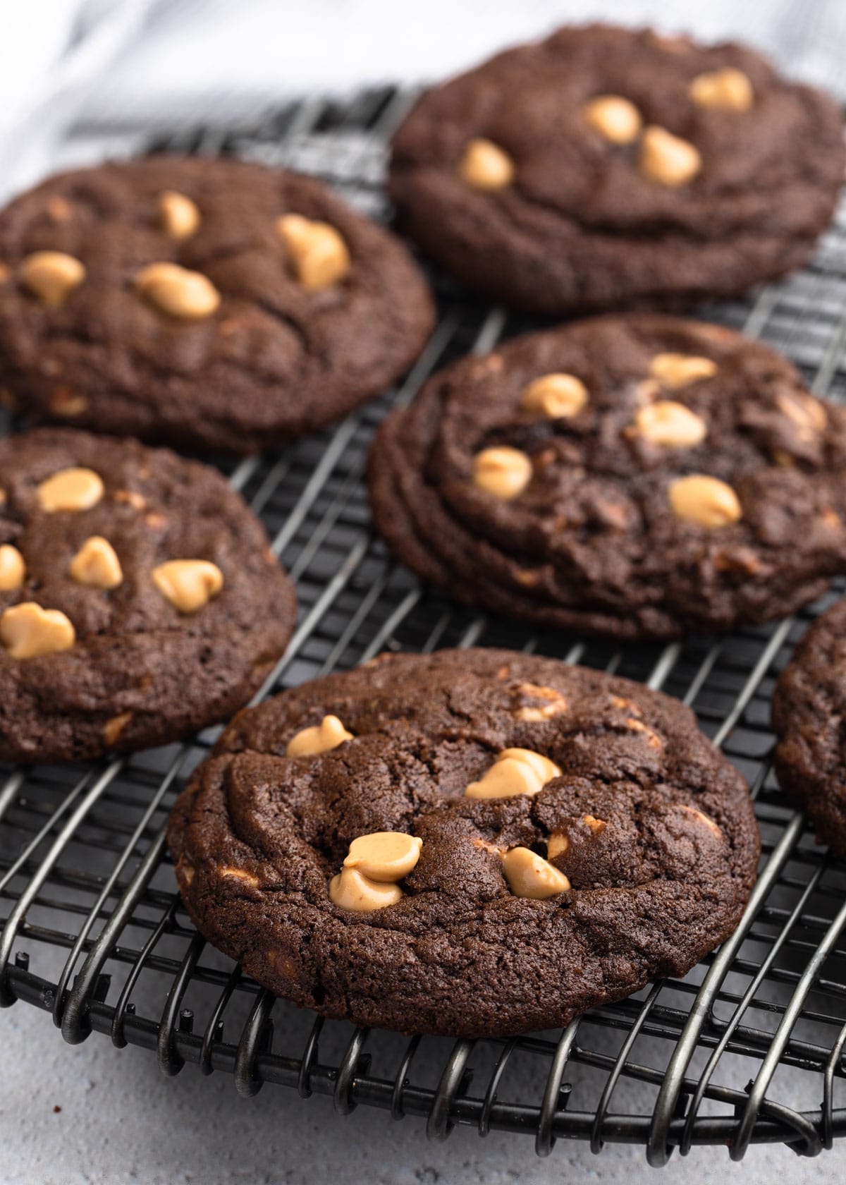 baked chocolate peanut butter chip cookies on a black wire cooling rack