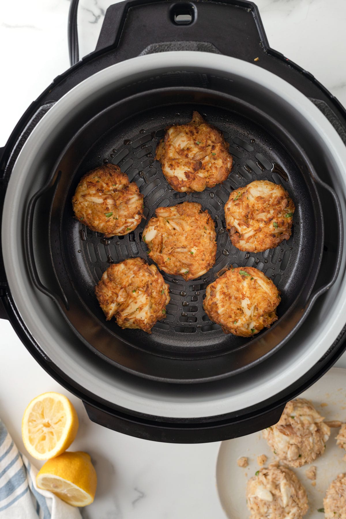 overhead of cooked crab cakes in an air fryer basket