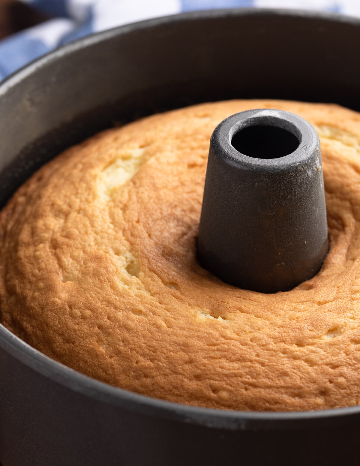 closeup side view of a baked vanilla pound cake in a tube pan