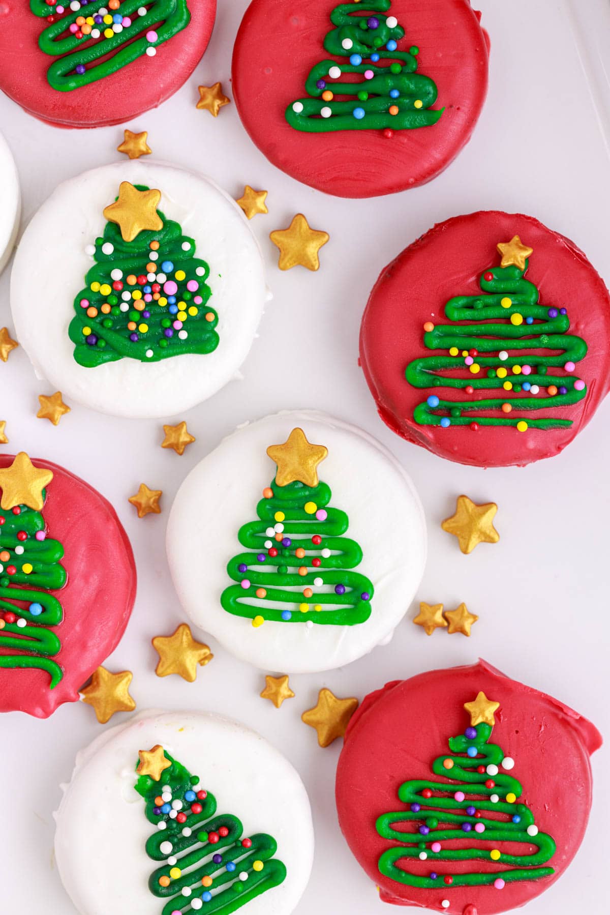 overhead of dipped oreo christmas tree cookies on a white background