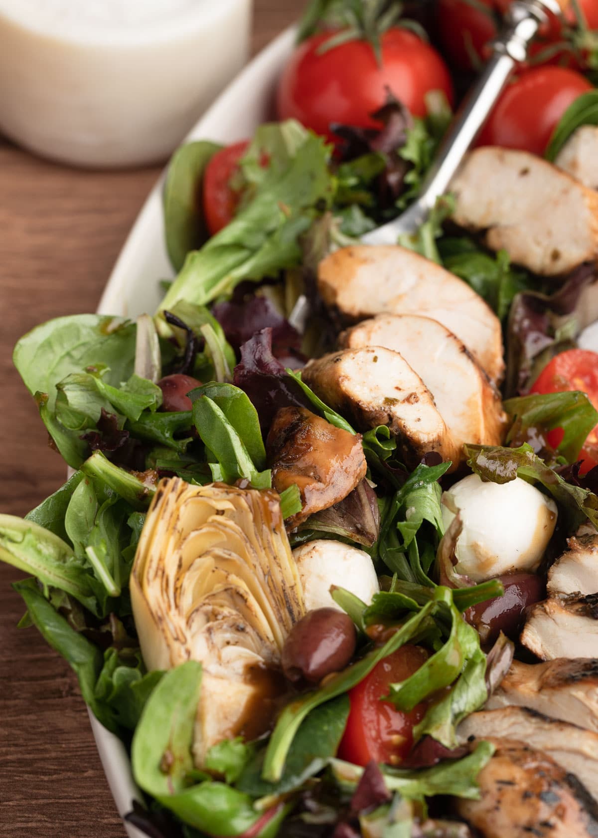 closeup of balsamic grilled chicken salad on a white ceramic platter