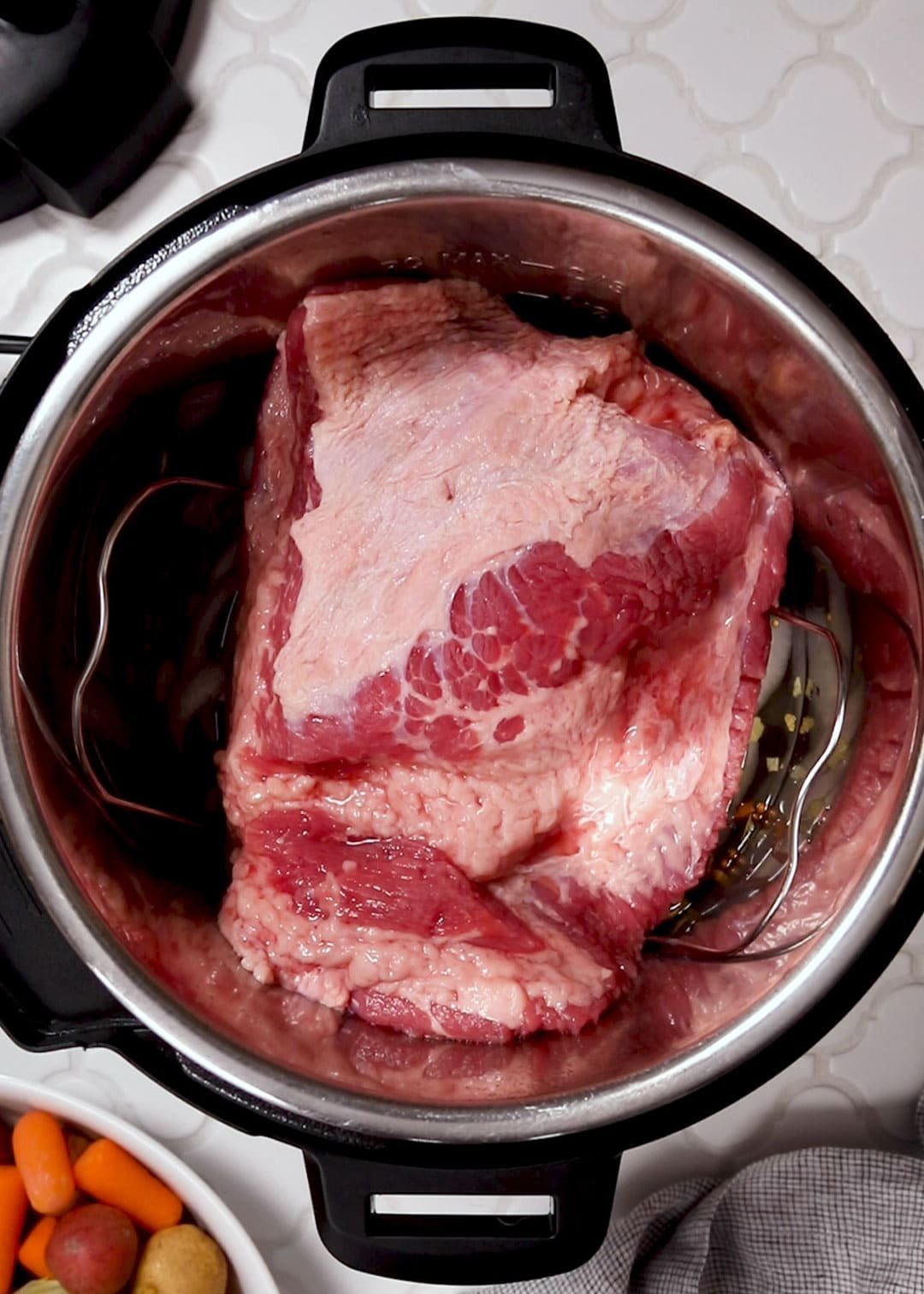 uncooked flat cut corned beef brisket on a trivet in an Instant Pot