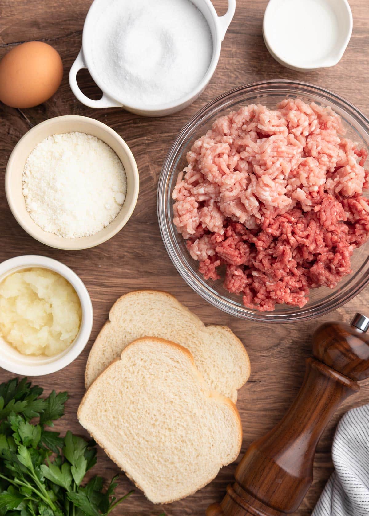 overhead photo of the ingredients needed to make meatballs for Italian Wedding Soup on a wood background