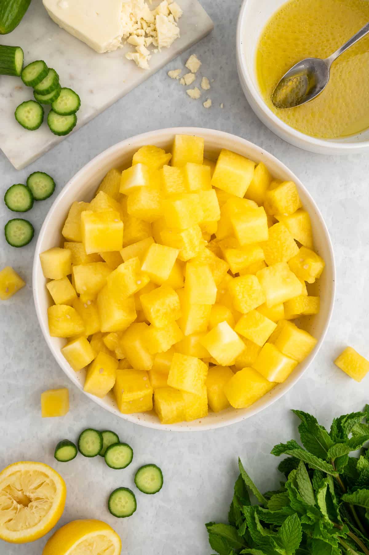 cubed yellow watermelon in a white bowl