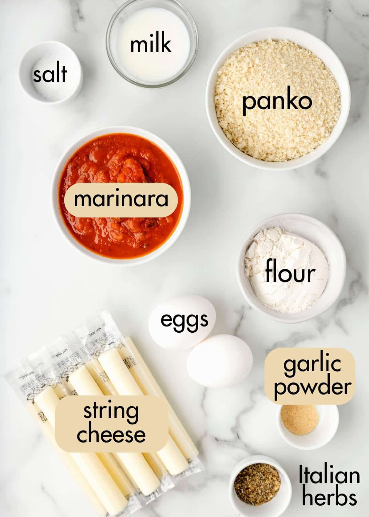 overhead photo of ingredients needed to make air fried mozzarella sticks on a white marble background