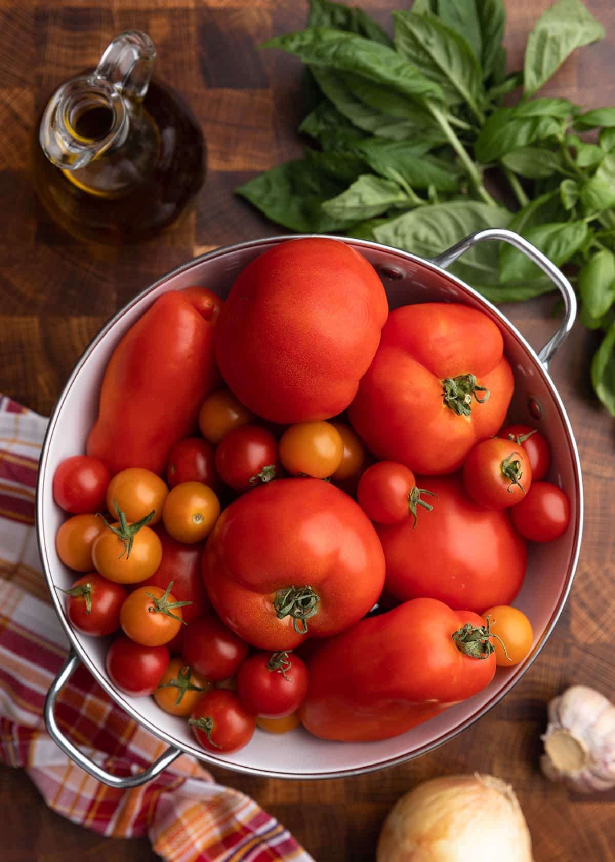 overhead photo of assorted tomatoes in a colander