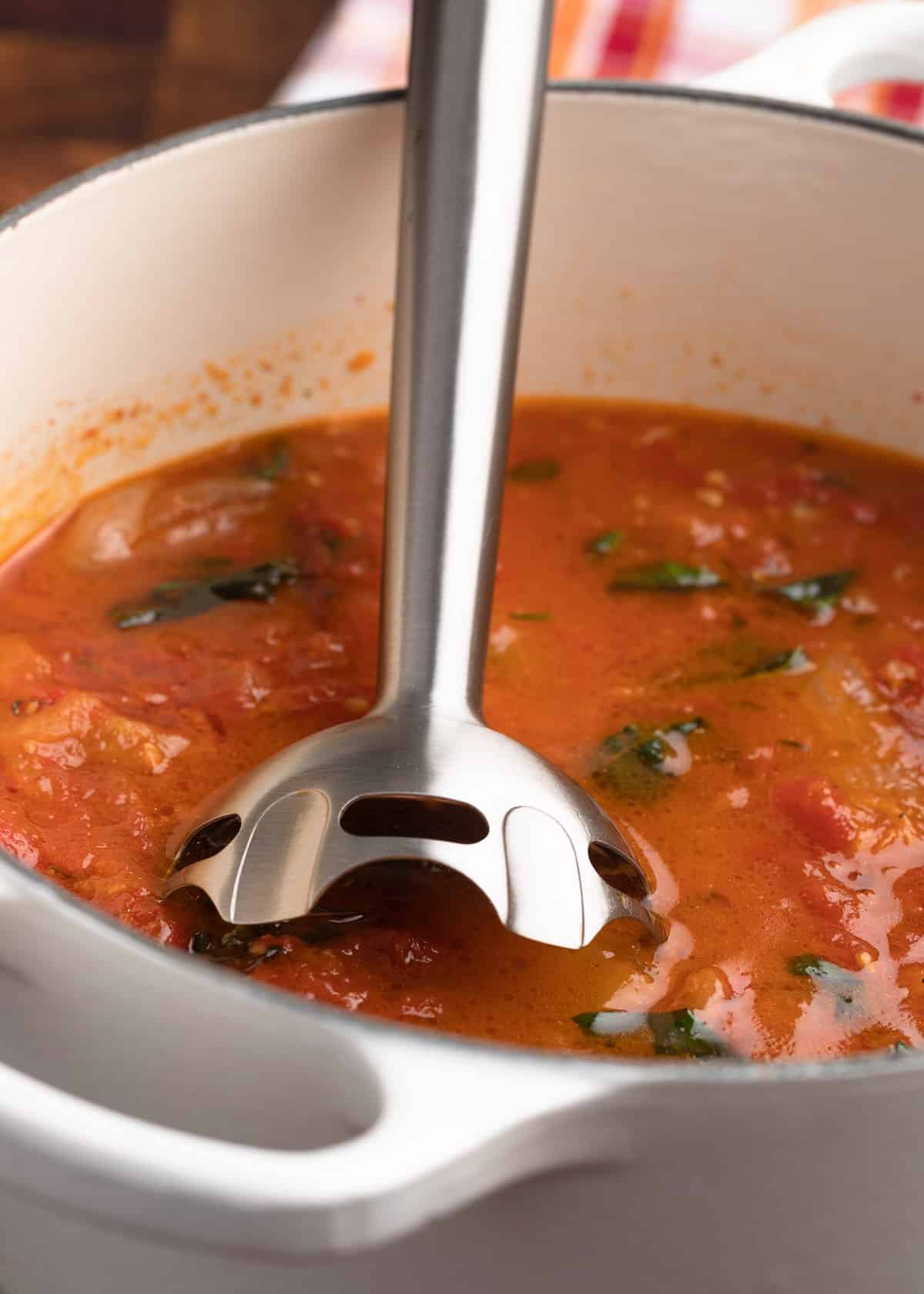 immersion blender in a dutch oven filled with roasted tomato soup