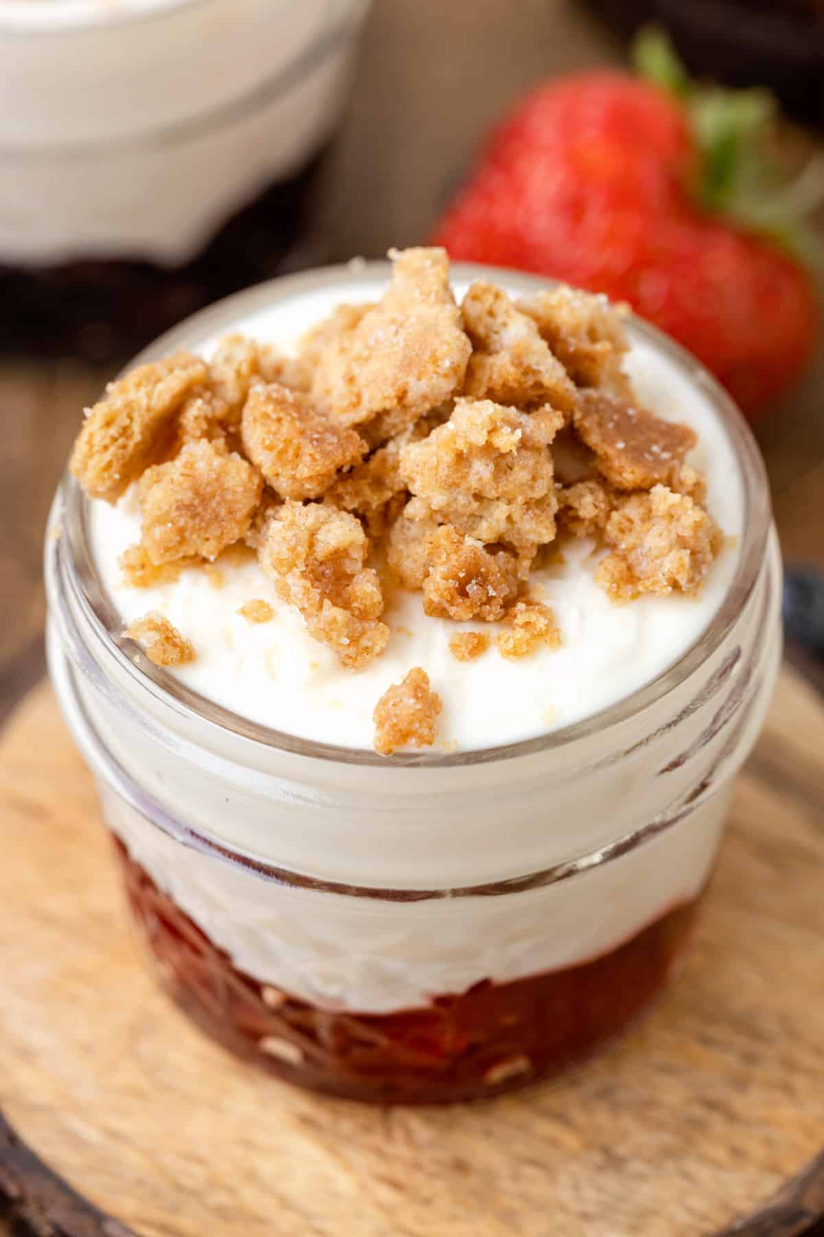 closeup of no bake cheesecake dessert with graham crumbles in a glass jar
