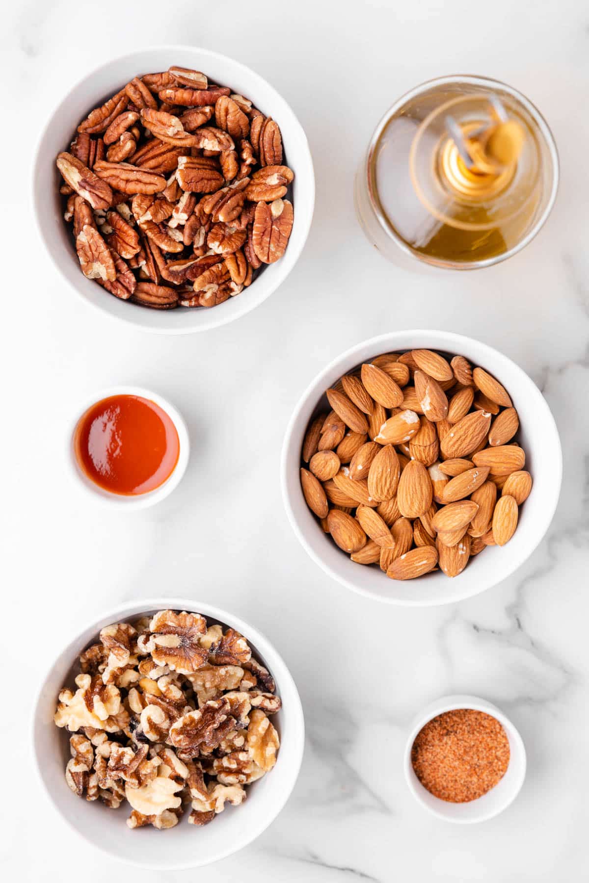 overhead photo of bowls of ingredients needed to make cajun spicy mixed nuts