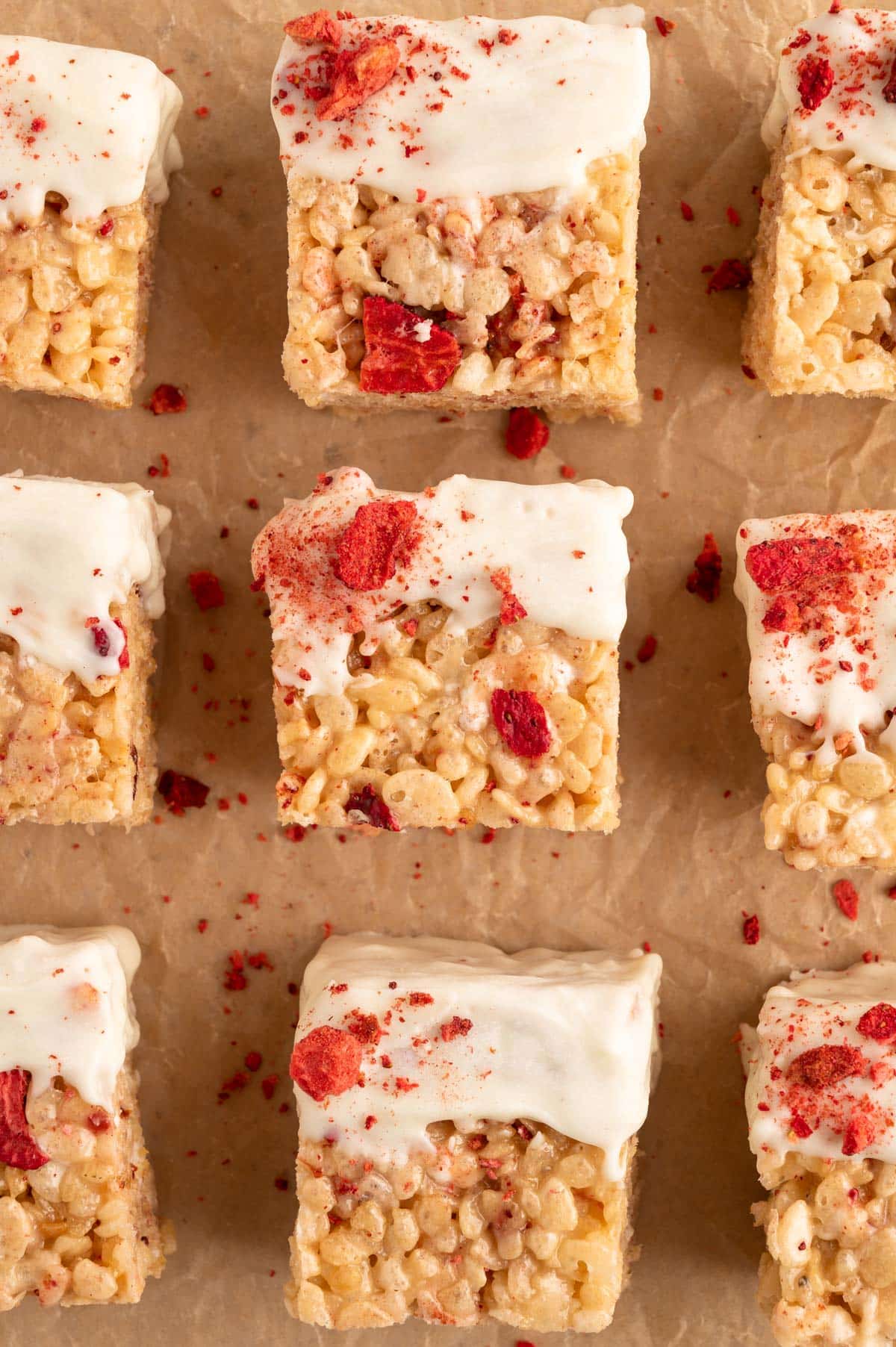 white chocolate dipped strawberry rice krispie treats on parchment
