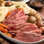 slow cooker corned beef cabbage and potatoes on an ivory ceramic platter