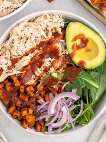 closeup overhead photo of a bbq shredded chicken salad with avocado, sweet potato, and red onion