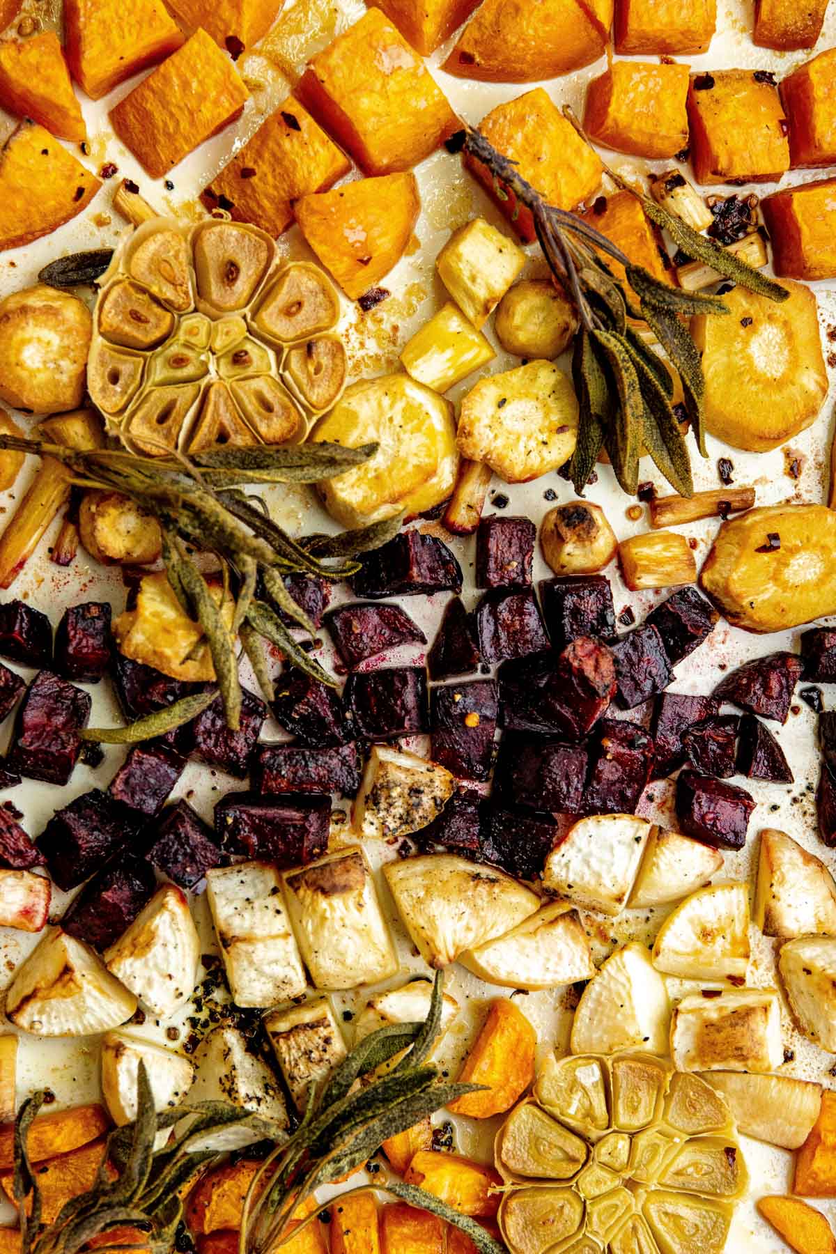 overhead photos of roasted root vegetables with crispy sage leaves on a baking sheet