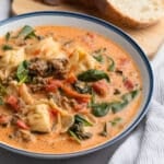 Creamy Tortellini Sausage Soup in a blue-rimmed white ceramic bowl