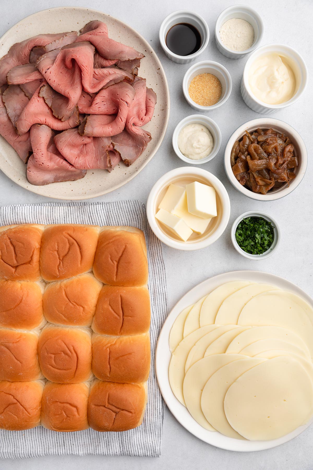 overhead photo of French Dip Slider ingredients in bowls on a white board