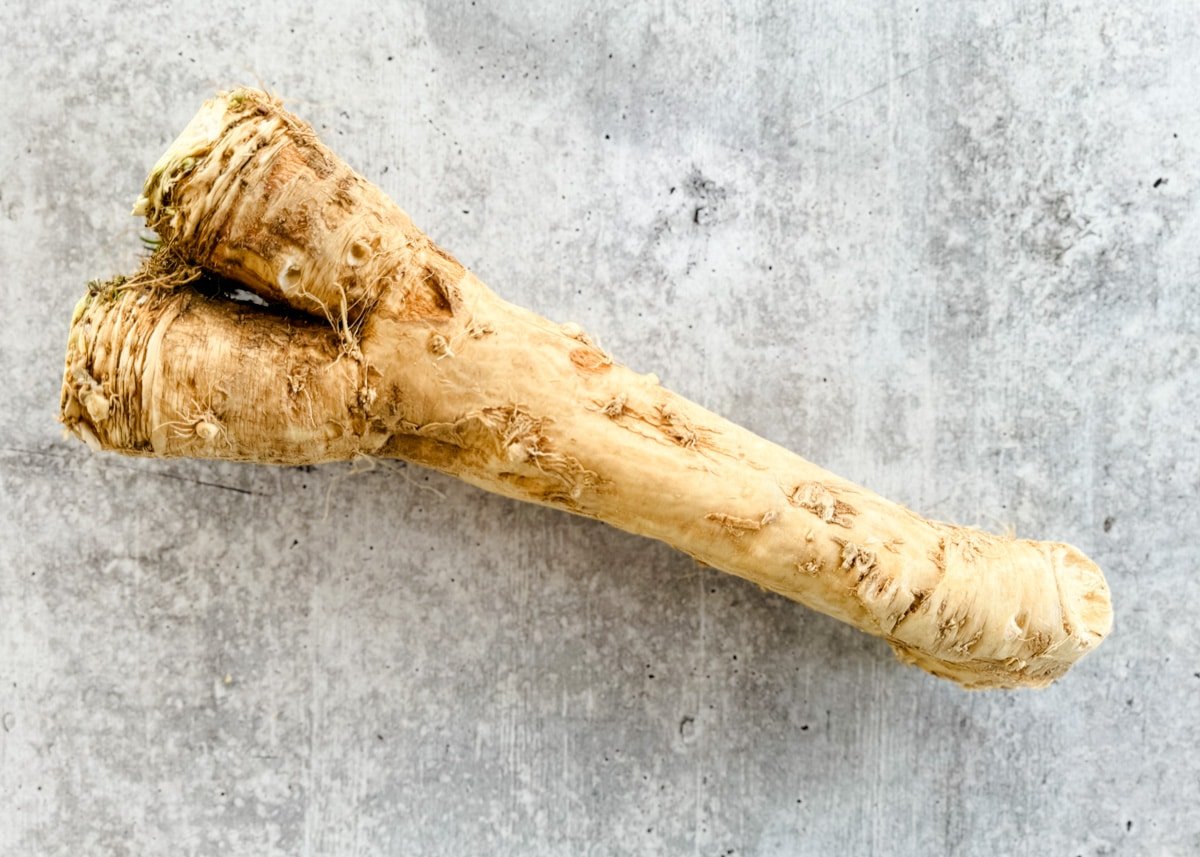 overhead of fresh horseradish root on a gray board