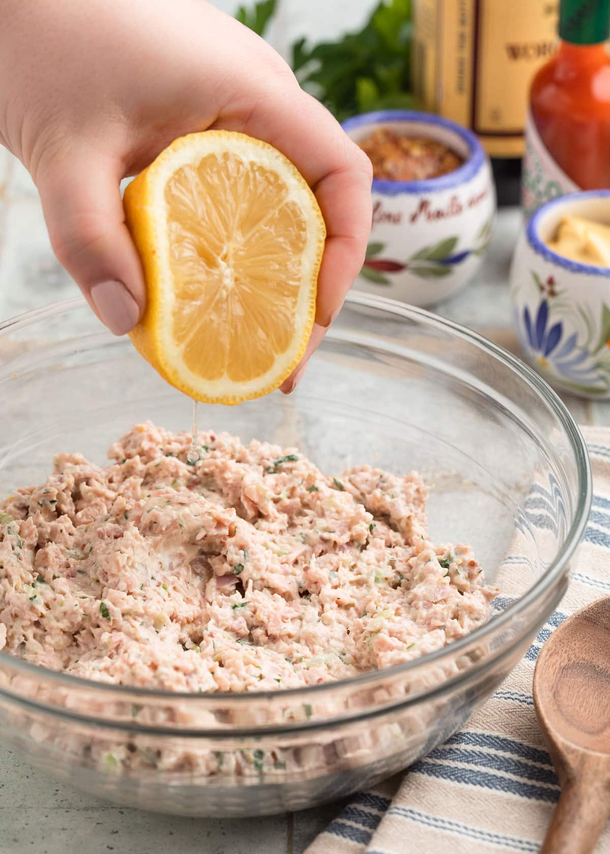 squeezing fresh lemon juice into a glass bowl of Deviled Ham spread