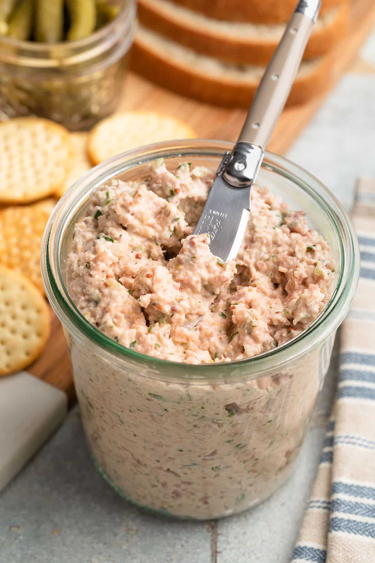 deviled ham spread in a glass jar with a spreader
