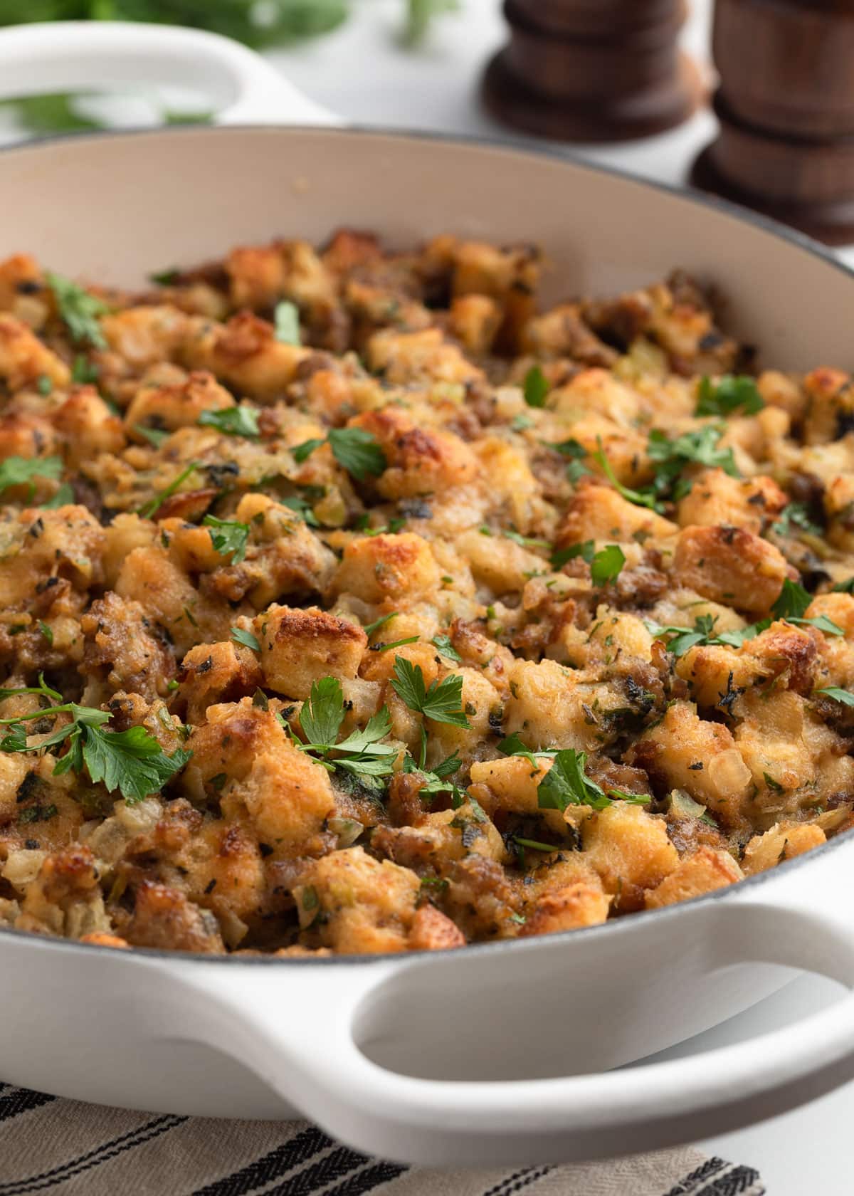 Italian sausage stuffing baked in a white enameled cast iron gratin dish