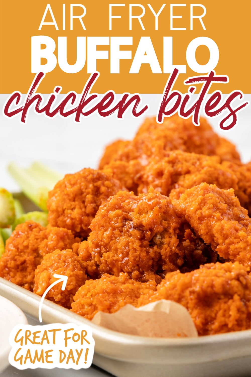 air fryer buffalo chicken piled onto a parchment lined baking sheet with celery sticks behind them. Text reads "Air Fryer Buffalo Chicken Bites" "Great for Game Day!"