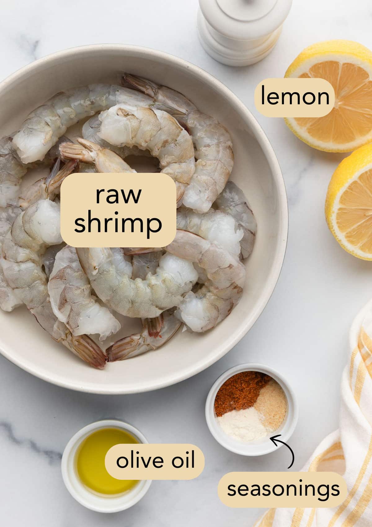 raw shrimp, olive oil, and ground spices in bowls next to a halved lemon. Ingredients have text label overlays.