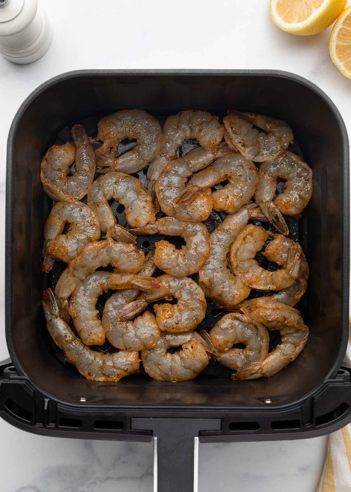 raw seasoned shrimp in a square XL air fryer basket
