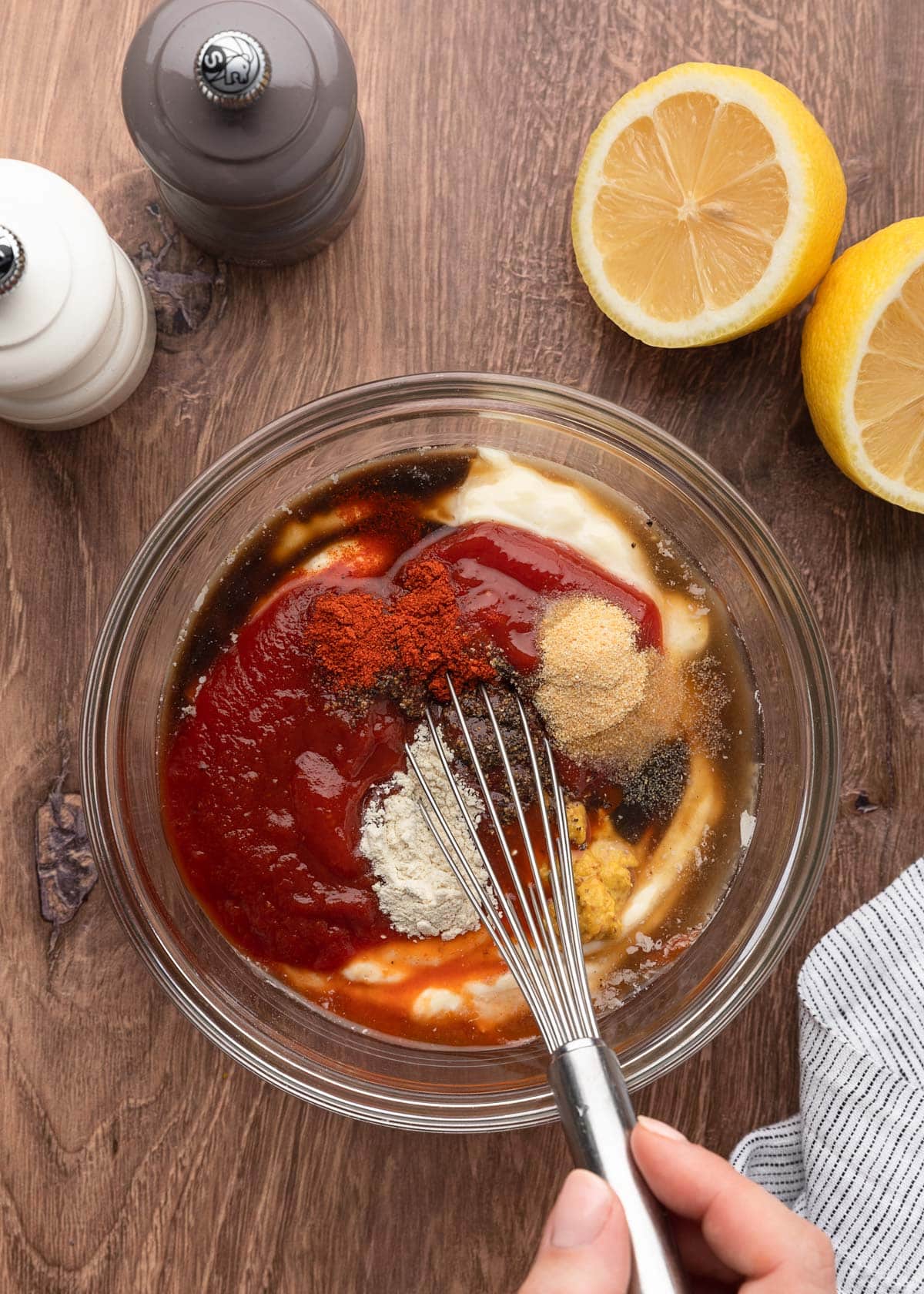 unmixed comeback sauce in a glass bowl with a whisk on a wood board