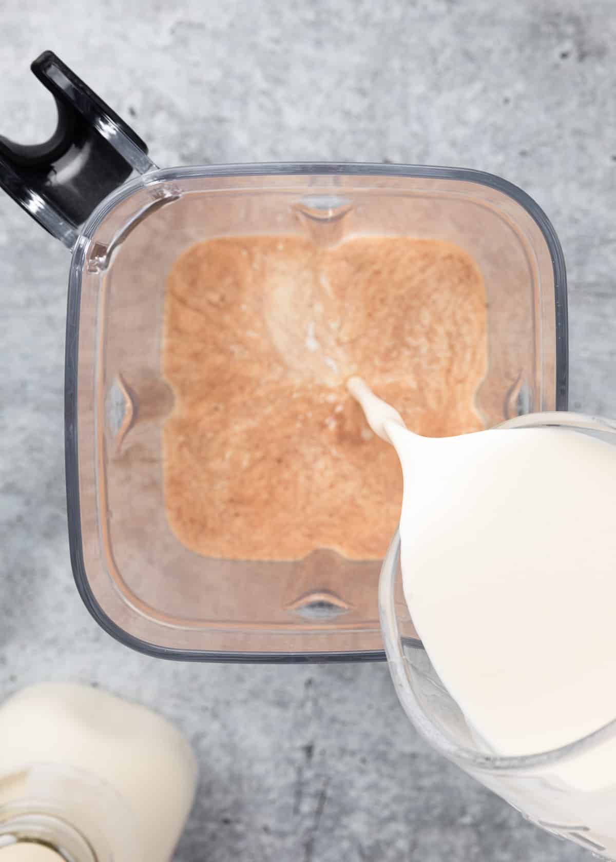 cream being poured into homemade Irish Cream in a blender canister