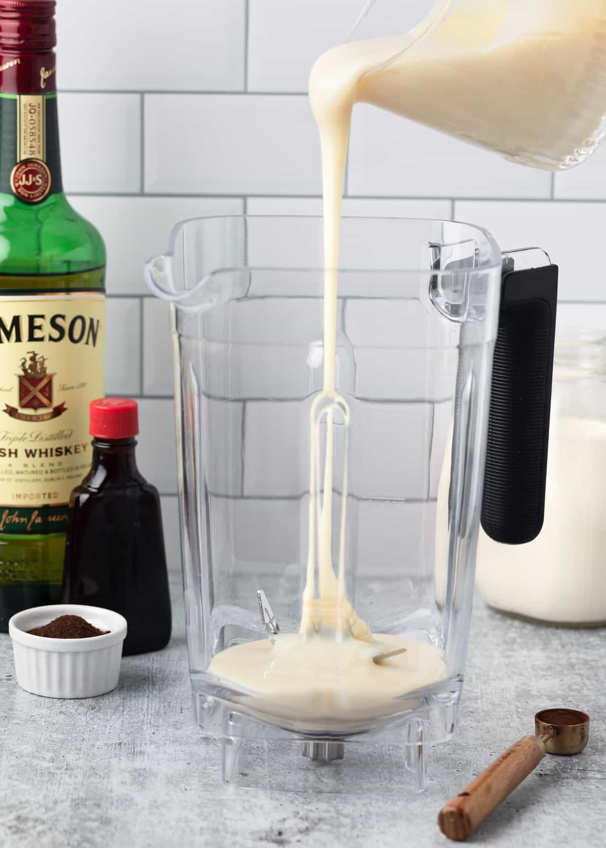 sweetened condensed milk being poured into a blender canister