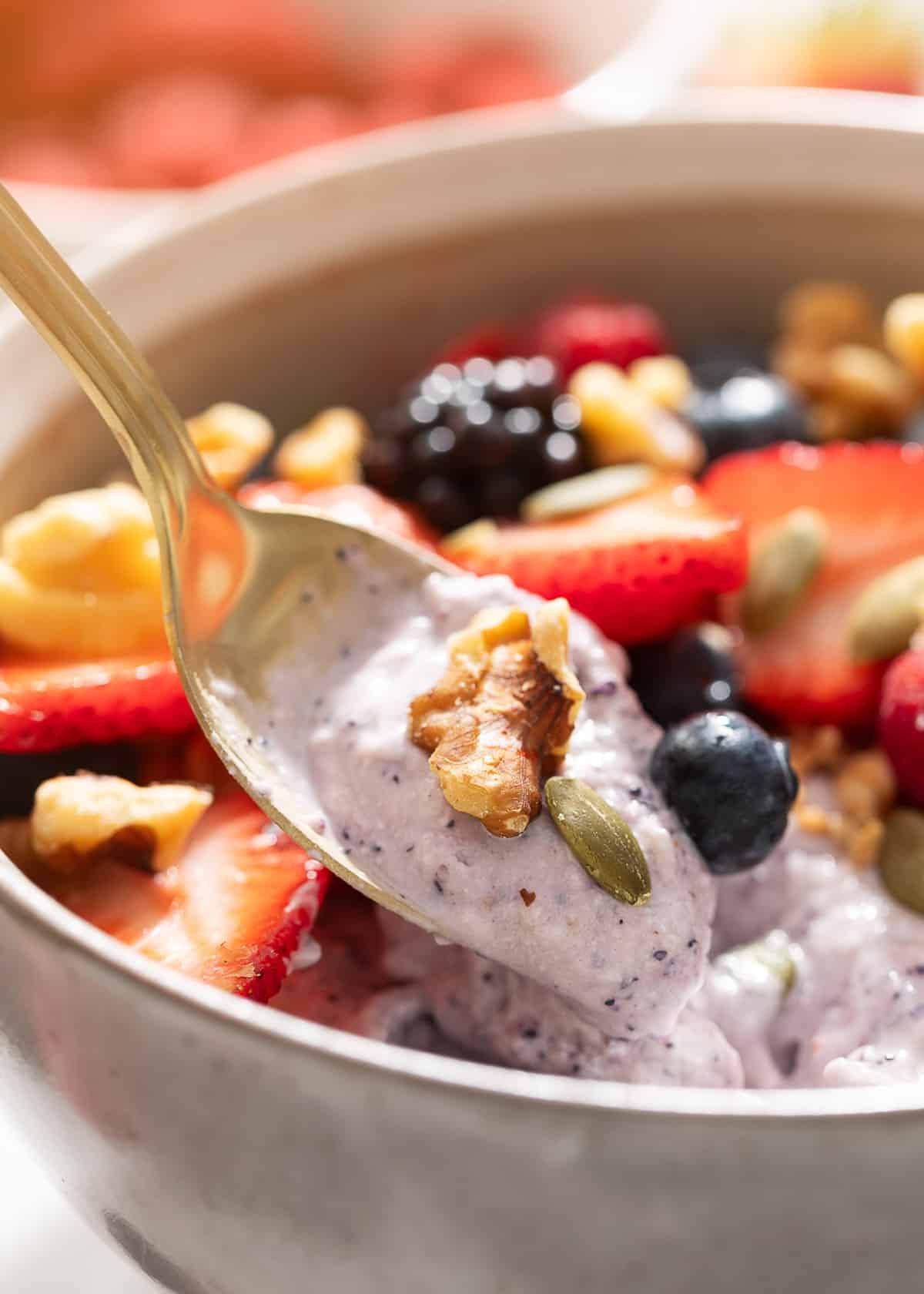 blueberry cottage cheese smoothie bowl being scooped with a gold spoon