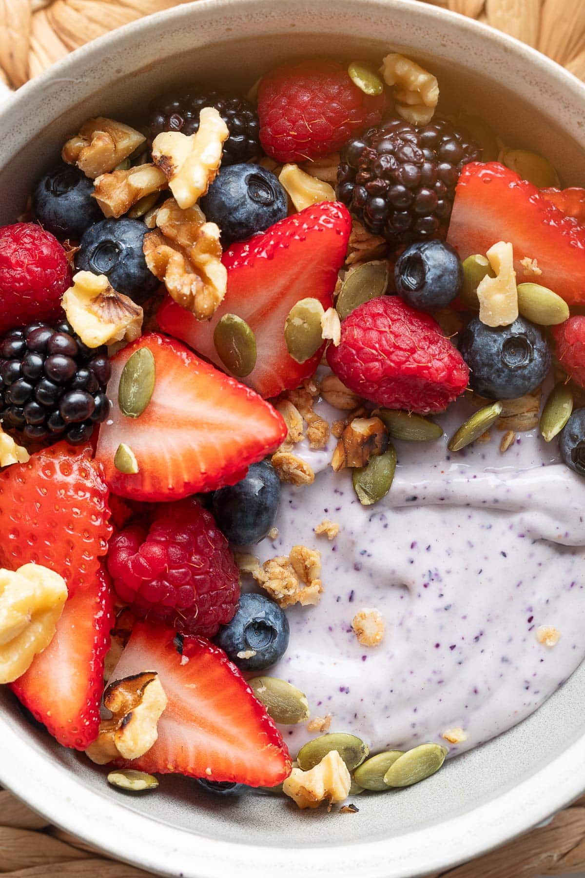 blueberry blended cottage cheese in a white bowl with mixed pepitas, pepitas, and walnuts