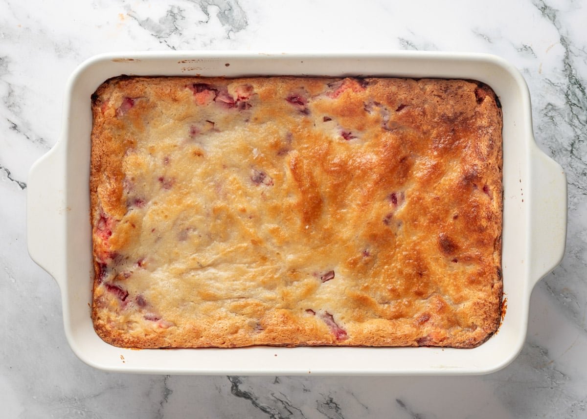 overhead of baked strawberry chess squares in a white baking dish on a white marble board