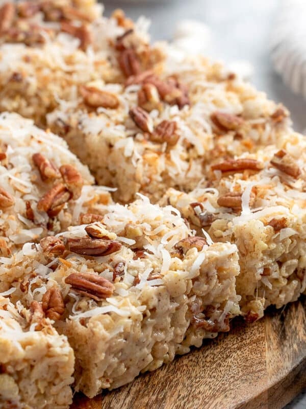 coconut pecan rice krispie treats cut into squares on a wooden serving board